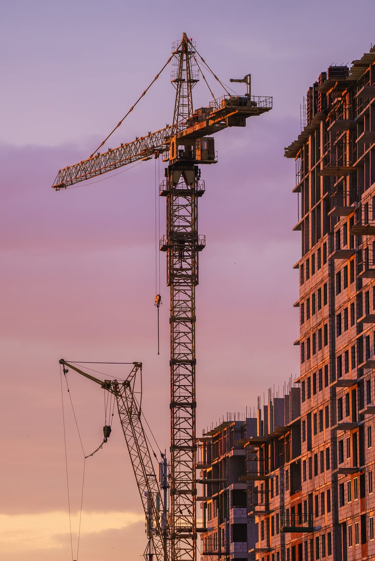 Residential construction project with cranes at sunset