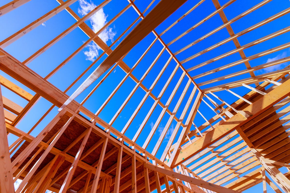 Construction workers building wooden frame beams